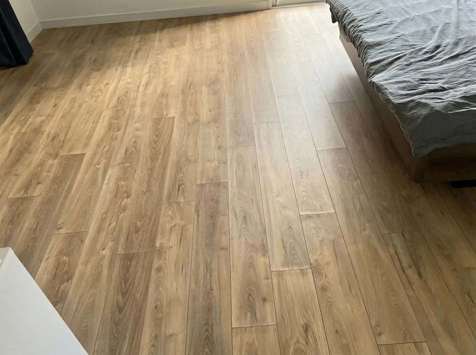 Pièce vide en cours de rénovation avec échelle en bois, pots de peinture colorés et rouleau au sol